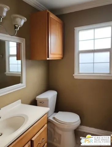 a bathroom with a sink a toilet and a window