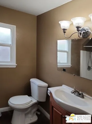 a bathroom with a sink a toilet and mirror