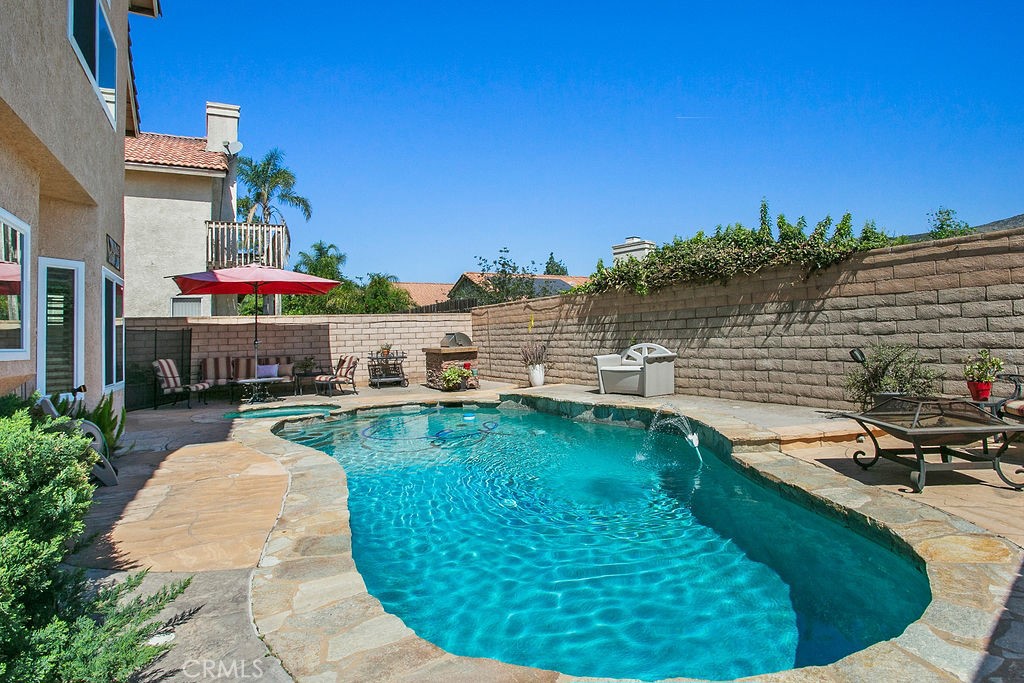 22720 Springmist Drive Moreno Valley, CA 92557 - Photo 24 of 40 a swimming pool with outdoor seating and barbeque oven