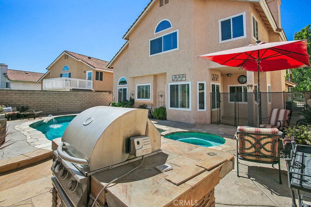 22720 Springmist Drive Moreno Valley, CA 92557 - Photo 26 of 40 a patio with a table and chairs under an umbrella