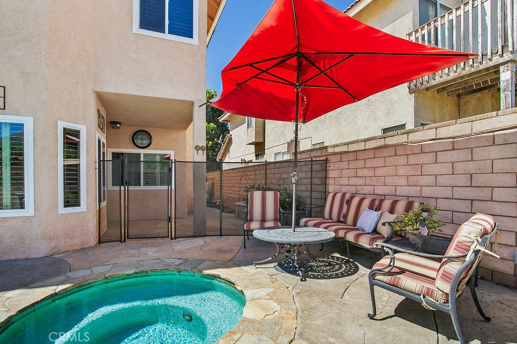 22720 Springmist Drive Moreno Valley, CA 92557 - Photo 28 of 40 a patio with a table and chairs under an umbrella