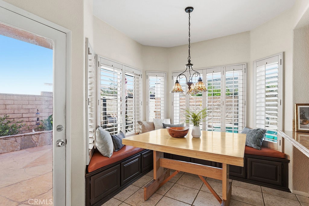 22720 Springmist Drive Moreno Valley, CA 92557 - Photo 8 of 40 a dining room with furniture a chandelier and wooden floor
