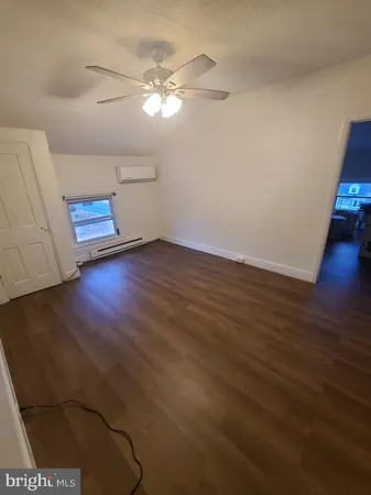 a view of a livingroom with wooden floor and a ceiling fan