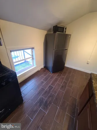 a view of a refrigerator in an empty room
