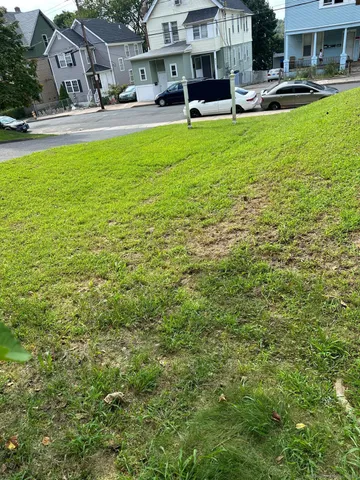 a view of a swimming pool with lawn chairs and a big yard