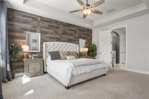 a spacious bedroom with a large bed and a chandelier