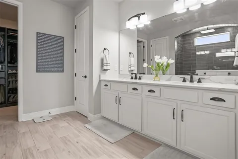 a spacious bathroom with a double vanity sink and mirror