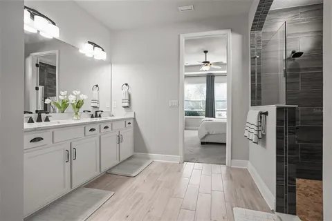 a en suite bathroom with a double vanity sink a mirror and a shower
