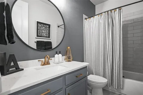 a bathroom with a sink mirror and toilet
