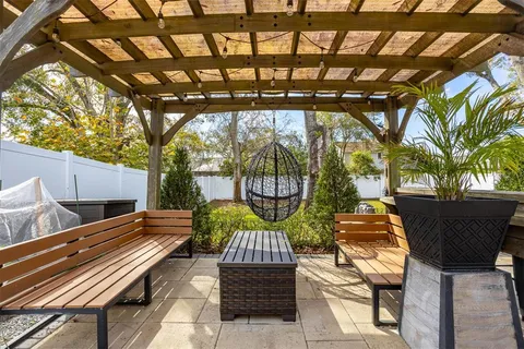 a backyard of a house with barbeque oven table and chairs