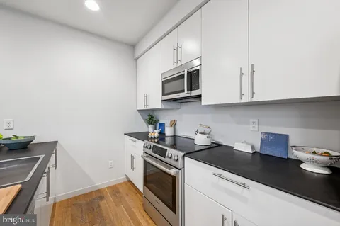 a kitchen with stainless steel appliances granite countertop a sink a stove and a microwave