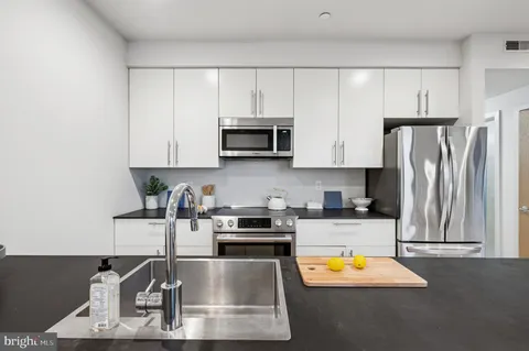 a kitchen with stainless steel appliances granite countertop a refrigerator sink and stove
