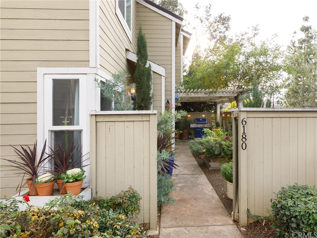 a backyard of a house with potted plants and couches