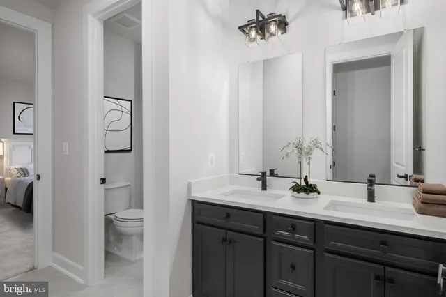 a bathroom with a double vanity sink toilet and shower