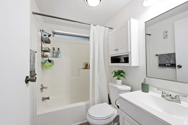 1525 South 400 East, Unit 13 Springville, UT 84663 - Photo 22 of 32 Bright bathroom featuring a white tub and shower combination with an integrated window, a white vanity with a single basin sink, and a wall-mounted storage cabinet