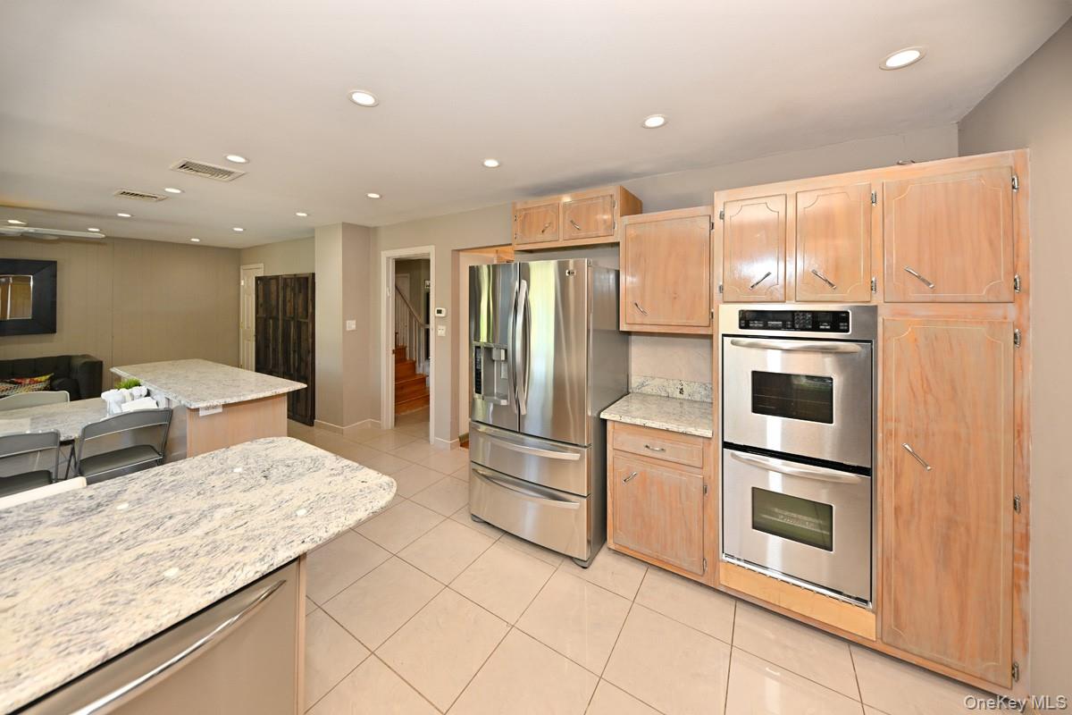 11 Deerwood Road Spring Valley, NY 10977 - Photo 34 of 34 a kitchen with stainless steel appliances kitchen island granite countertop a refrigerator oven a sink dishwasher and white cabinets with wooden floor