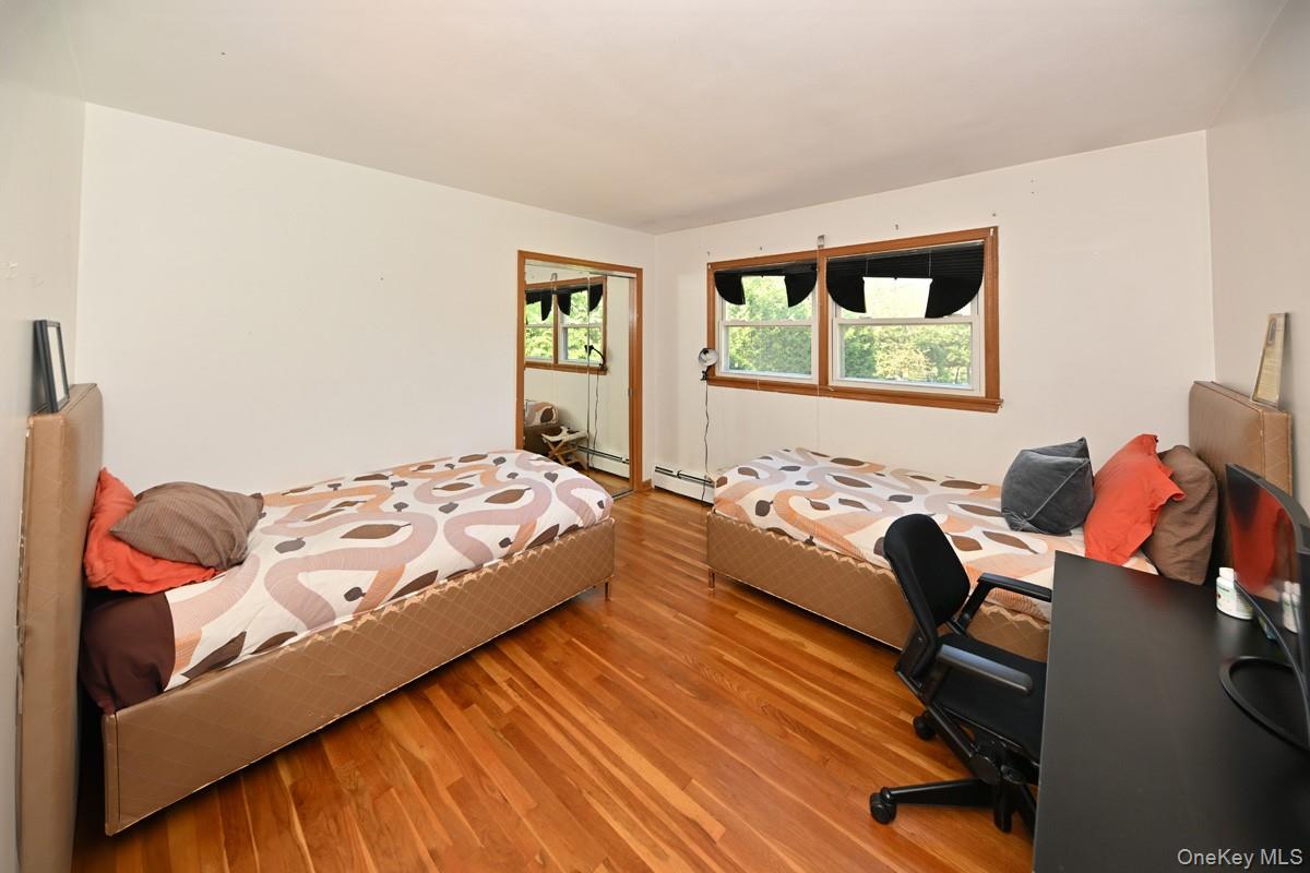 11 Deerwood Road Spring Valley, NY 10977 - Photo 26 of 34 a bedroom with a bed and wooden floor
