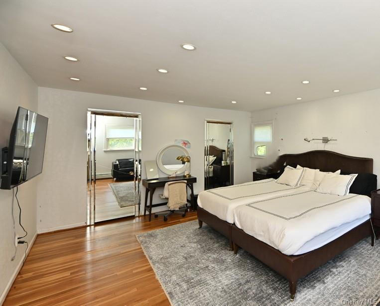 11 Deerwood Road Spring Valley, NY 10977 - Photo 27 of 34 a spacious bedroom with a bed a mirror on desk and wooden floor