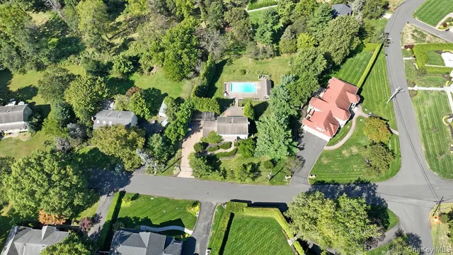 an aerial view of residential house with outdoor space and trees all around