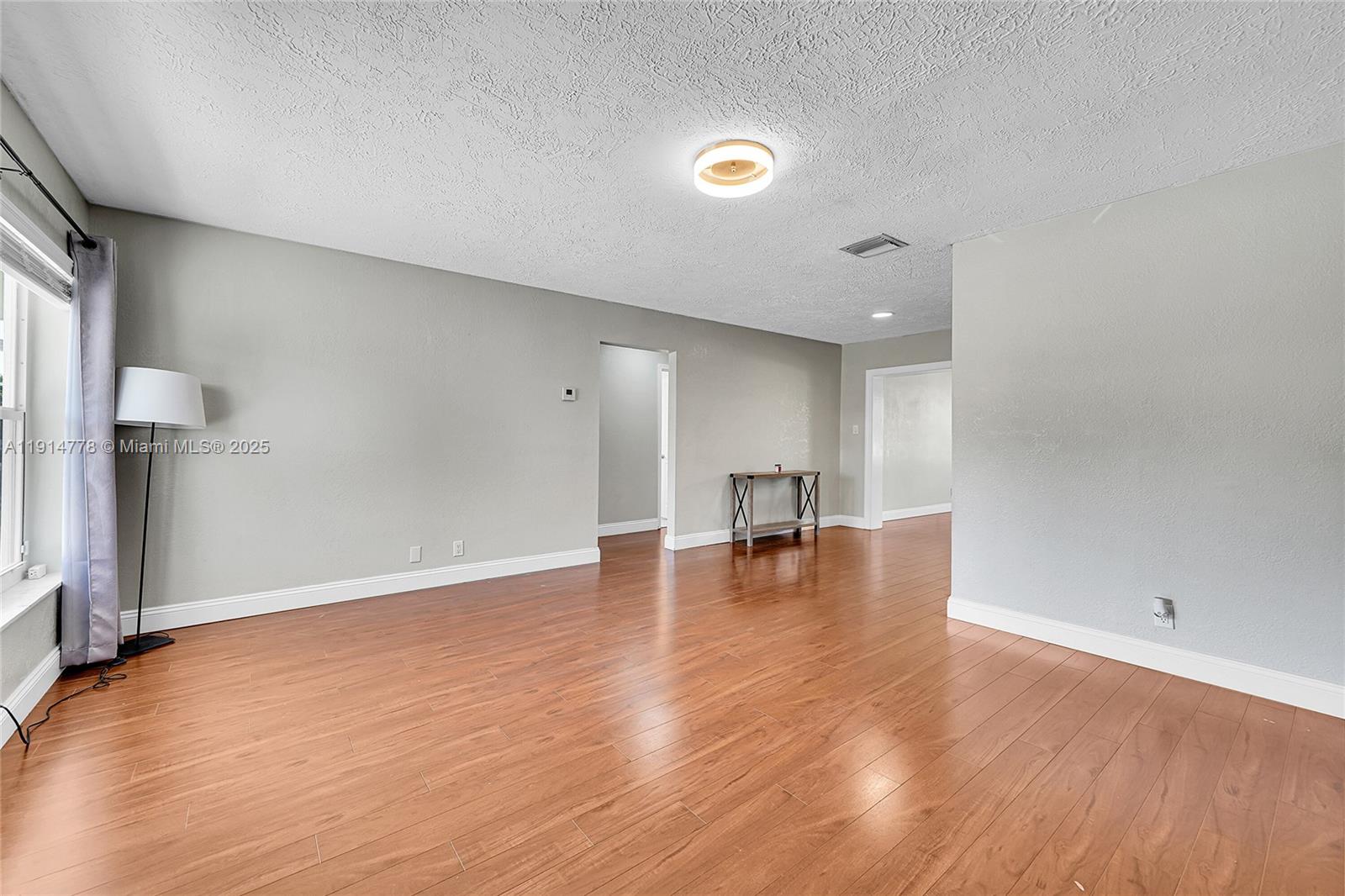 6001 Northwest 66th Terrace Tamarac, FL 33321 - Photo 2 of 30 a view of empty room with wooden floor and fireplace