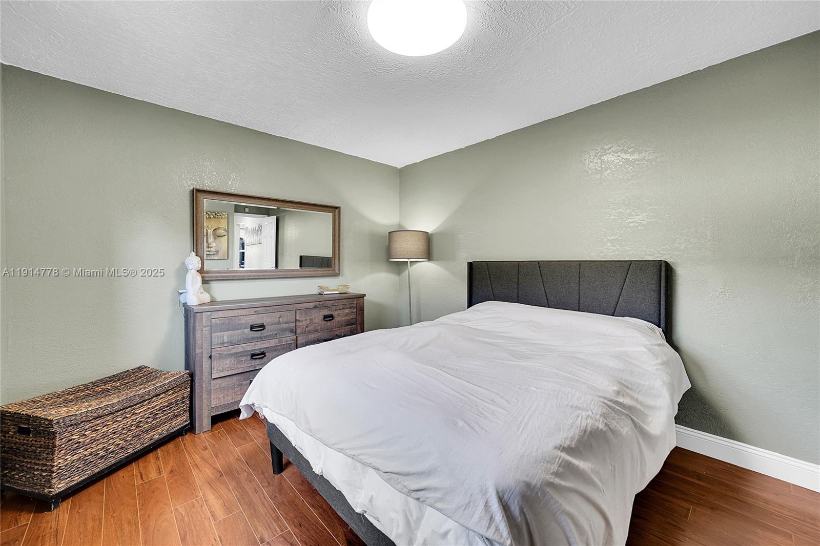 6001 Northwest 66th Terrace Tamarac, FL 33321 - Photo 25 of 30 a bedroom with a bed and wooden floor