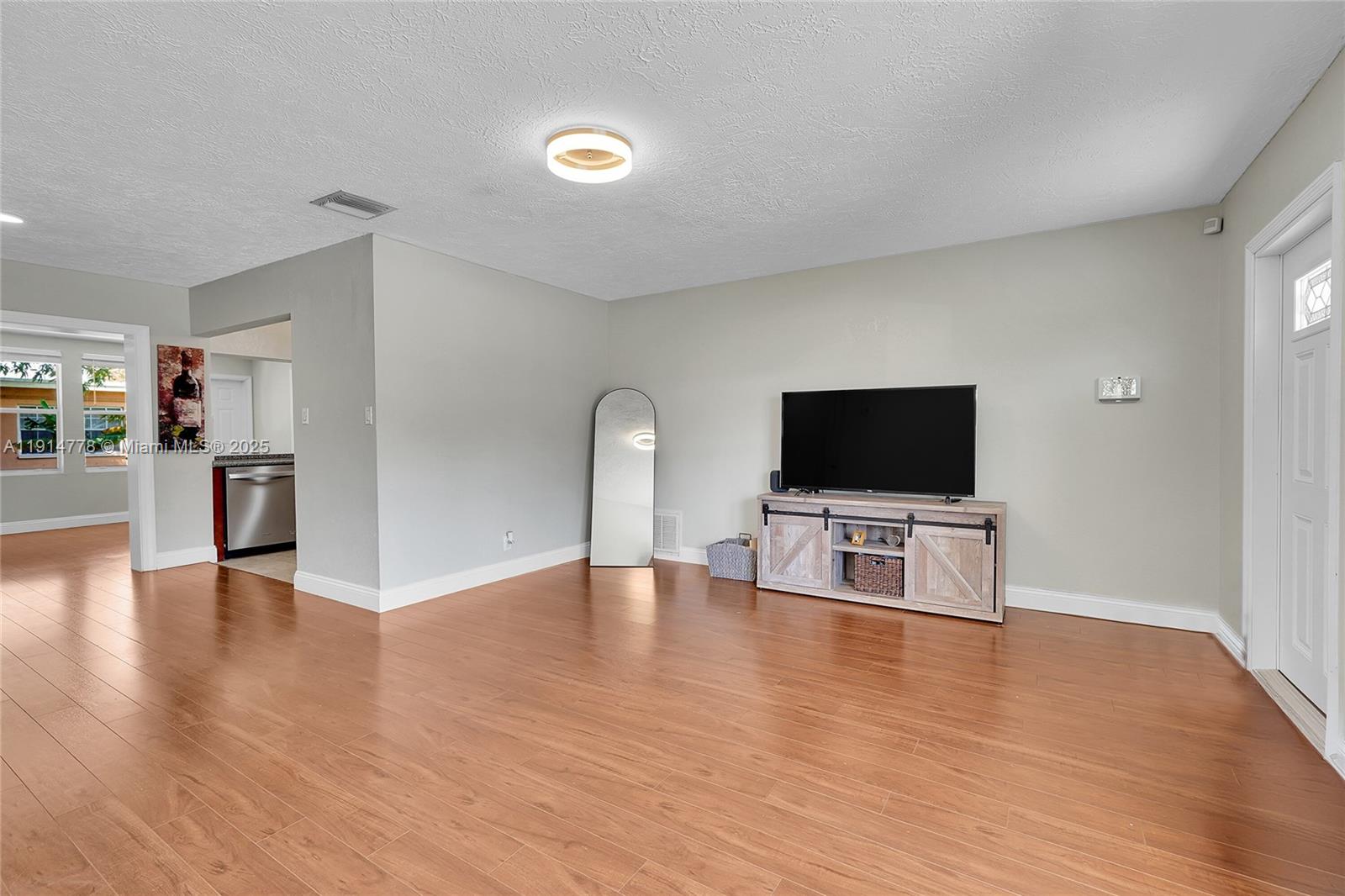 6001 Northwest 66th Terrace Tamarac, FL 33321 - Photo 5 of 30 a view of a livingroom with a flat screen tv wooden floor and a flat screen tv