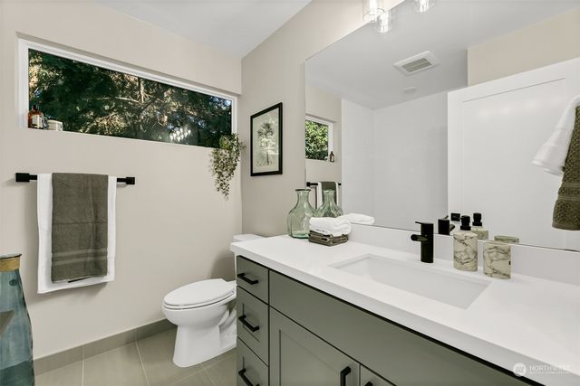 a bathroom with a sink a toilet and mirror