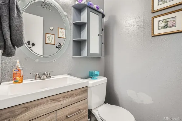 a bathroom with a toilet sink and mirror