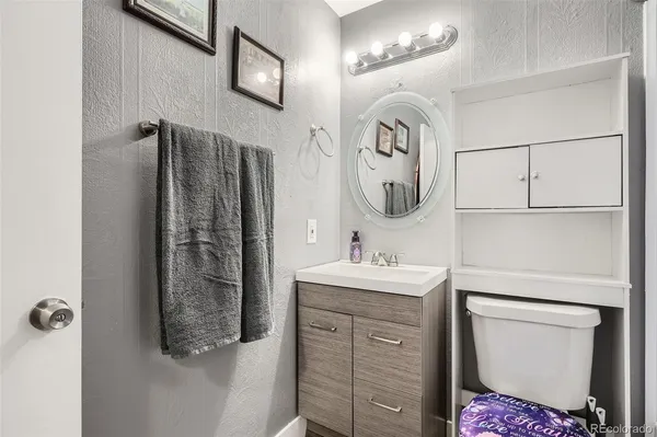 a bathroom with a toilet sink and mirror