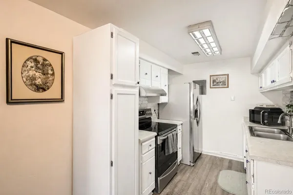 a kitchen with stainless steel appliances a white refrigerator a stove a sink and a refrigerator