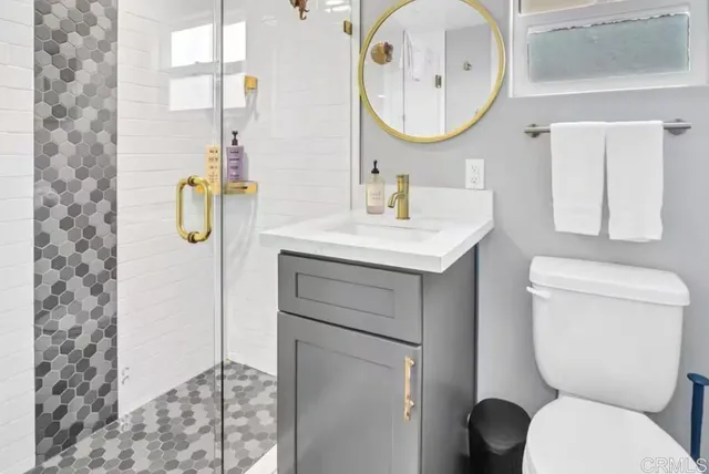 a bathroom with a toilet sink vanity and mirror