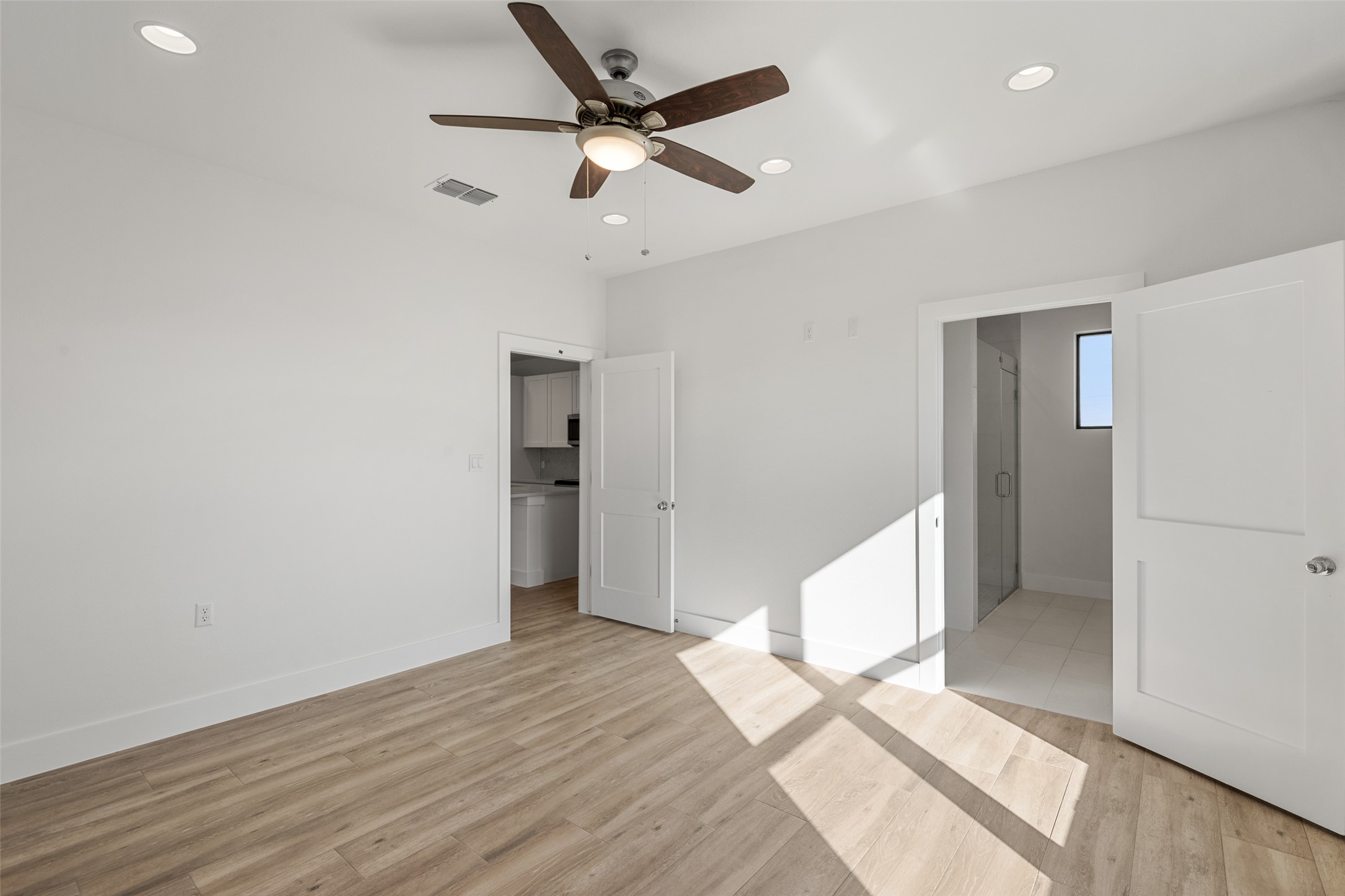 711 Paleface Ranch Road, Unit 3 Spicewood, TX 78669 - Photo 14 of 32 a view of an empty room with wooden floor and a ceiling fan
