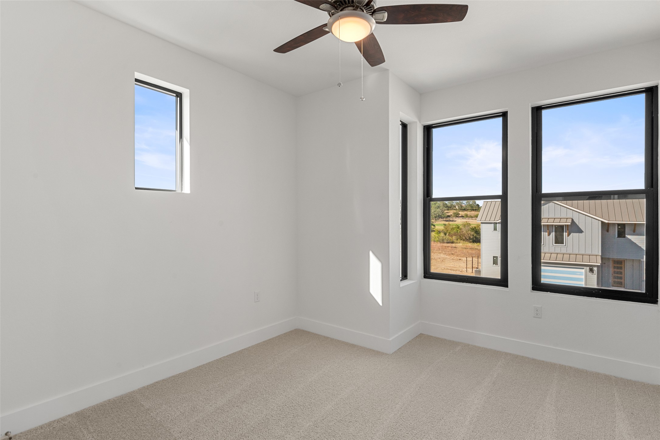 711 Paleface Ranch Road, Unit 3 Spicewood, TX 78669 - Photo 25 of 32 an empty room with windows and chandelier fan