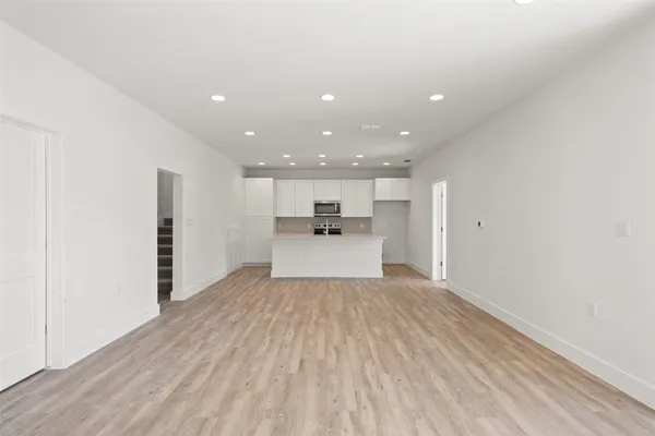 a view of a kitchen with a sink and dishwasher a refrigerator with wooden floor