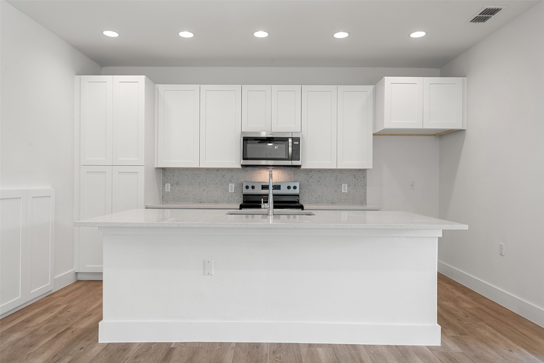 711 Paleface Ranch Road, Unit 3 Spicewood, TX 78669 - Photo 10 of 32 a view of kitchen with kitchen island a sink wooden floor and black appliances