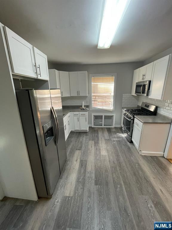 388-390 Leslie Street, Unit 1 Newark, NJ 07112 - Photo 19 of 21 a kitchen with a sink a refrigerator a stove a microwave and cabinets