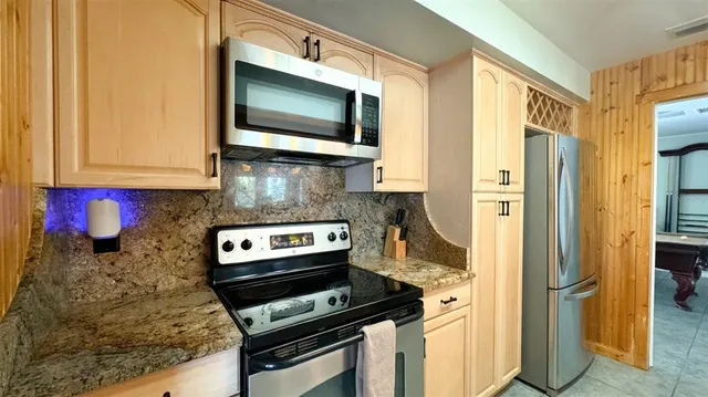 a kitchen with stainless steel appliances a stove a microwave and wood cabinets