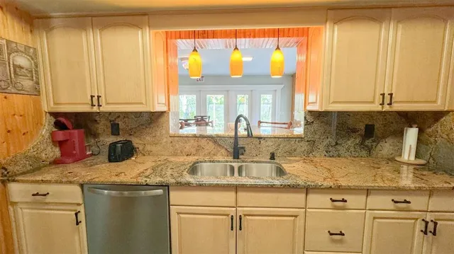 a kitchen with stainless steel appliances granite countertop a sink and cabinets