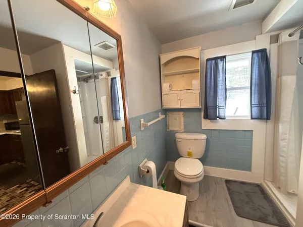 a bathroom with a toilet and a shower