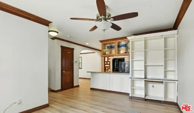 a view of a livingroom with wooden floor and a ceiling fan