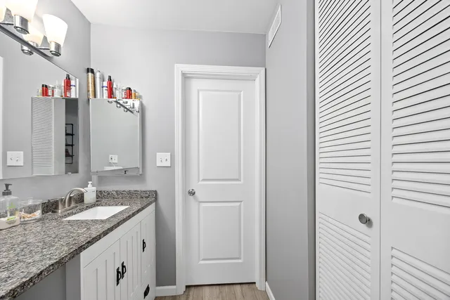 a bathroom with a granite countertop shower and a sink