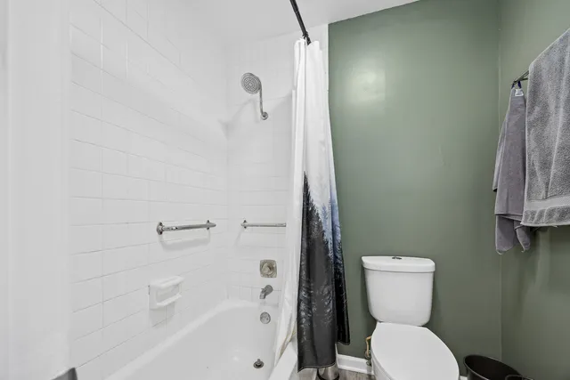 a white toilet sitting next to a bath tub
