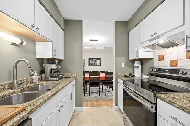 a kitchen with stainless steel appliances granite countertop a sink and a stove