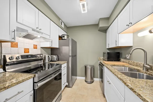 a kitchen with stainless steel appliances granite countertop a sink stove and refrigerator
