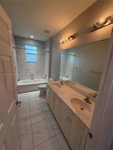 a large white bathroom with a sink mirror and a bathtub