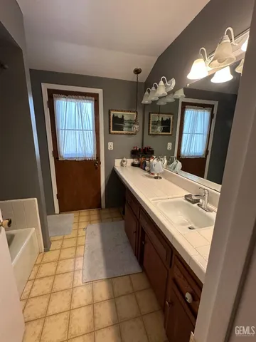a bath room with a sink a vanity and a mirror