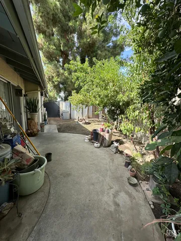 a view of a backyard with table and chairs and potted plants