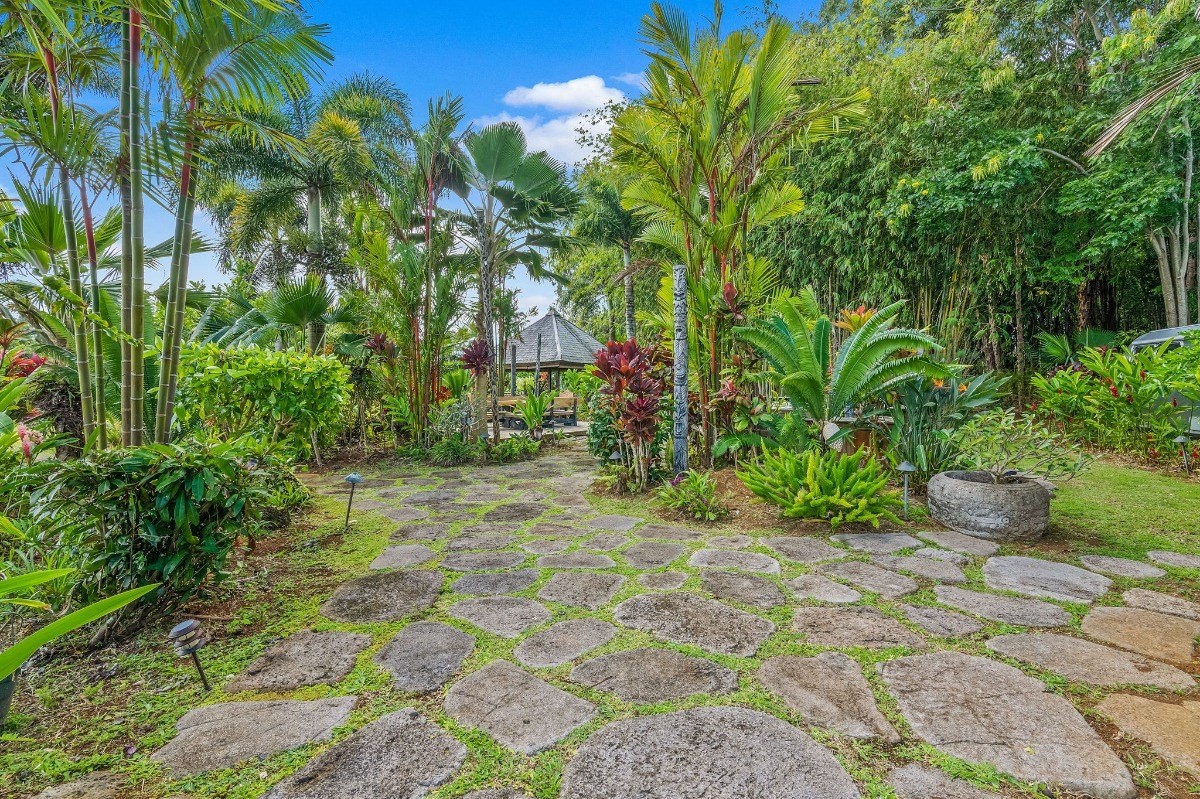 St, Unit 5 Kilauea, HI 96754 - Photo 13 of 26 a view of a backyard with potted plants and large trees