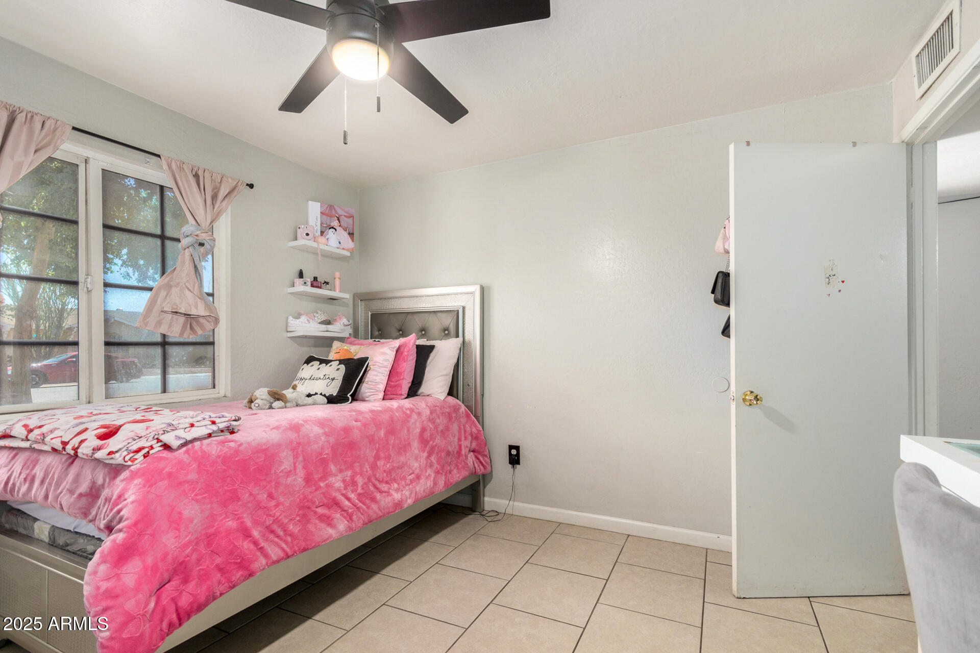 6224 West Berkeley Road Phoenix, AZ 85035 - Photo 19 of 27 a bedroom with a bed and a chandelier
