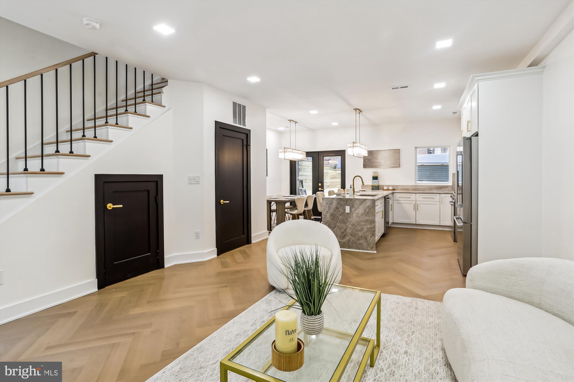 a living room with kitchen island furniture and a chandelier